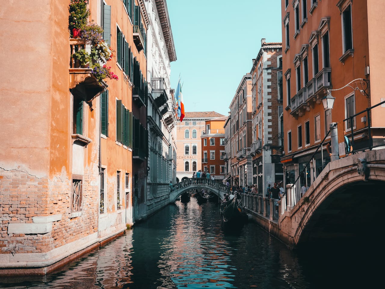 Beautiful view of a Venetian canal with classic architecture and a bridge under a sunny sky.